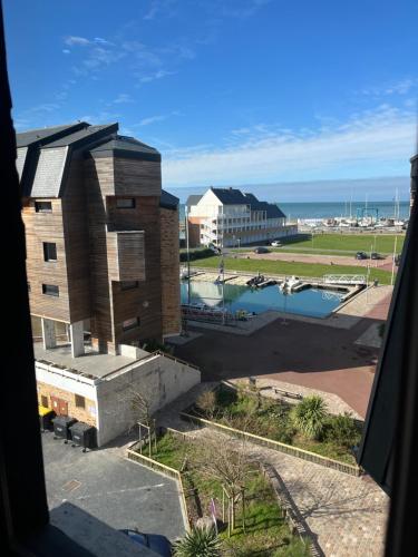 une vue depuis une fenêtre d'un bâtiment et d'un port dans l'établissement Mon balcon face à la mer - les Marinas Deauville, à Deauville