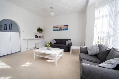 a living room with two couches and a table at Modern Flat in Porthcawl in Porthcawl