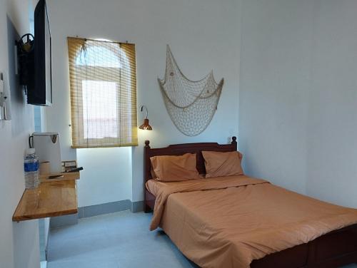 1 dormitorio con 1 cama con una red en la pared en Nhà bốn chín, en Ấp Khánh Phước (1)