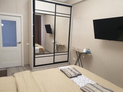 een kamer met een bed en een grote spiegel bij Elegance 1BD apartment with living room in Chişinău