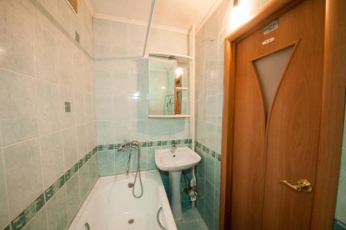 a bathroom with a bath tub and a sink at Kvartirov Apartment at Surikova in Krasnoyarsk