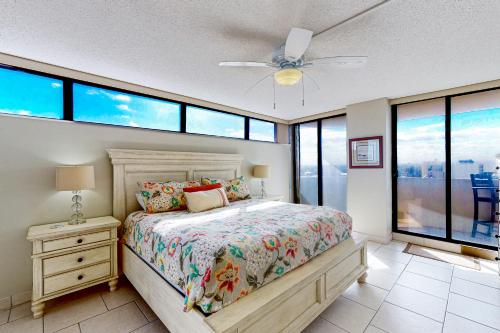 Un dormitorio con una cama y un ventilador de techo. en Daytona Beach Living - Unit #504, en Daytona Beach
