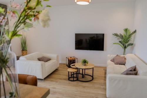 a living room with two white couches and a table at Luxe 4 persoons appartement in Residence Marina Kamperland 2c in Kamperland