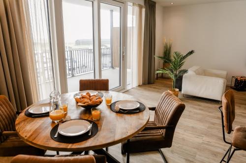 a dining room with a table and chairs and a large window at Luxe 4 persoons appartement in Residence Marina Kamperland 2c in Kamperland