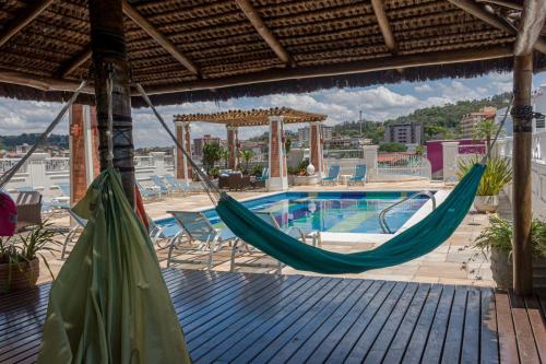 a resort with a hammock and a swimming pool at Hotel Firenze in Serra Negra