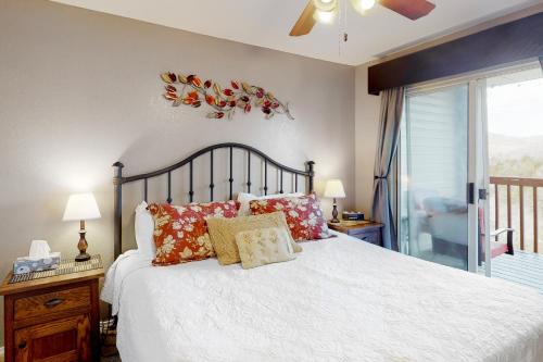 a bedroom with a white bed with pillows and a window at Woodpecker Lane Retreat in Branson