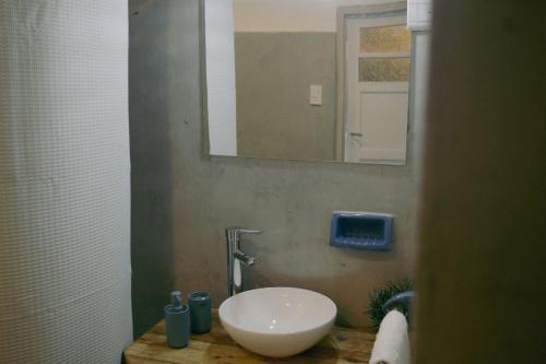 een badkamer met een witte wastafel en een spiegel bij El Alero Hospedaje in Mendoza