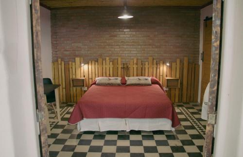 een slaapkamer met een bed in een bakstenen muur bij El Alero Hospedaje in Mendoza