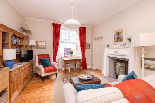 a living room with a couch and a fireplace at Charming Hideaway in Edinburgh City Centre in Edinburgh