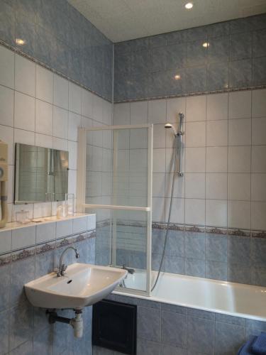 une salle de bain avec un lavabo, une douche et une baignoire dans l'établissement Hôtel De Paris, à Charleville-Mézières