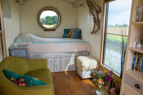 een kleine slaapkamer met een bed en een raam bij de Veldwachter in 't Zand