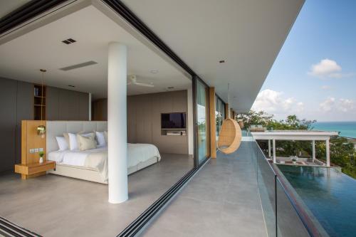 a bedroom with a bed and a view of the ocean at Villa Amylia Emerald, design excellence in Koh Samui