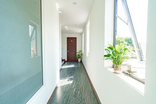 an empty hallway with a window and plants at Golden Star Villa Hoi An in Hoi An