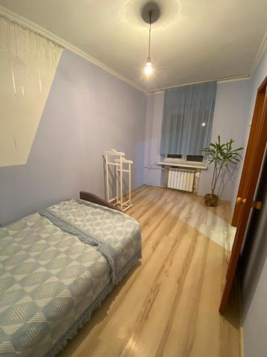 een slaapkamer met een bed en een houten vloer bij Лофт in Tsjernivsi