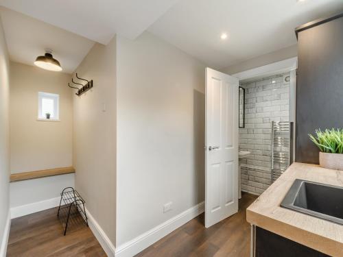 - une cuisine avec des murs blancs et un évier dans l'établissement Grosvenor House, à Alnwick