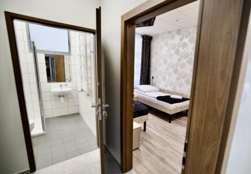 Habitación con baño con cama y espejo. en Hostel OPEN GARDEN, en Częstochowa