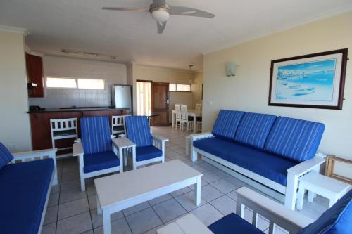 ein Wohnzimmer mit blauen Sofas und eine Küche in der Unterkunft Santana 406 in Margate
