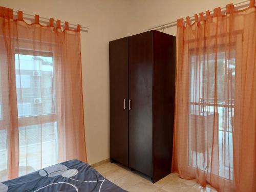 sypialnia z szafką, łóżkiem i oknem w obiekcie Apartman Lozančić w mieście Vir