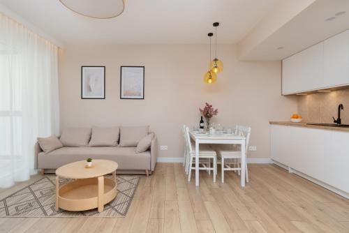 uma sala de estar com um sofá e uma mesa em Beaufort Estate Apartment by Renters em Gdynia