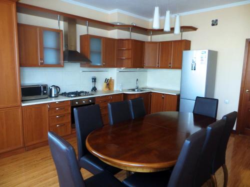 a kitchen with a table and chairs and a refrigerator at Bishkek House Apartament in Bishkek