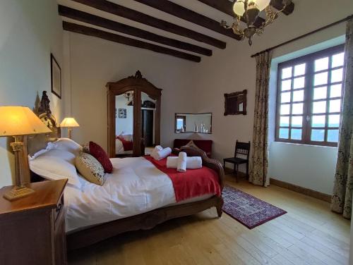 a bedroom with a large bed and a large window at Château de Chauvac - Chambres et table d'hôtes avec vue sur la rivière in Bassignac-le-Bas