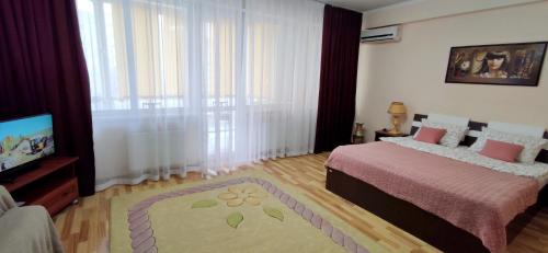 a bedroom with a bed and a flat screen tv at Apartment.md in Chişinău
