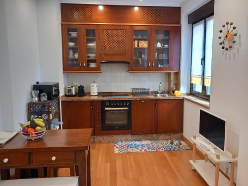 a kitchen with wooden cabinets and a wooden table at MenVal16 in Gijón