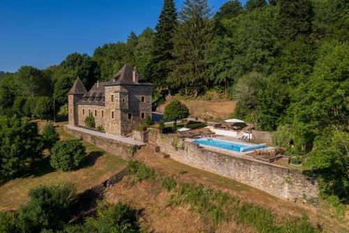 un domaine dans les montagnes avec une piscine dans l'établissement Château de Chauvac - Chambres et table d'hôtes avec vue sur la rivière, à Bassignac-le-Bas