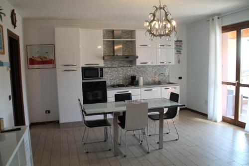 a kitchen with a table and chairs and a chandelier at CASA VACANZE DA RIKI APPARTAMENTO 2 in Peschiera del Garda