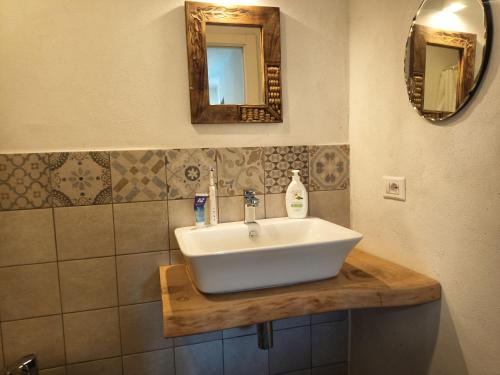 een badkamer met een witte wastafel en een spiegel bij B&B Sant'Anna in Cairo Montenotte