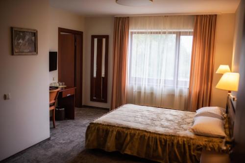 - une chambre avec un lit et une fenêtre avec un bureau dans l'établissement Vingis, à Marijampolė