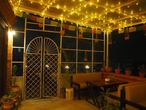 a patio with lights and a door and a table at The Nest Guest House in Changunarayan