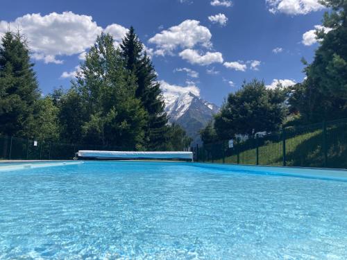 une piscine avec une montagne en arrière-plan dans l'établissement Le cocon du Bettex 1400 - Cozy Apt near Mont Blanc, à Saint-Gervais-les-Bains