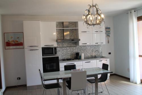a kitchen with a table and chairs and a chandelier at CASA VACANZE DA RIKI APPARTAMENTO 2 in Peschiera del Garda