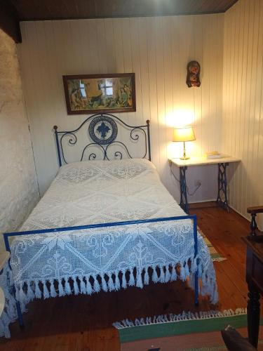 a bedroom with a bed with a blue and white bedspread at Casas do Durão-Memories House in Lajeosa