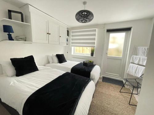 a bedroom with two beds and a couch and a window at Cambridge Stay Cozy home with Wi-Fi, Parking Perfect for 2 in Cherry Hinton