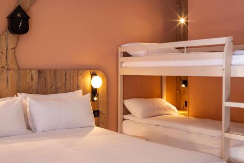 two bunk beds in a room with two white beds at ibis Styles Les Houches Chamonix in Les Houches