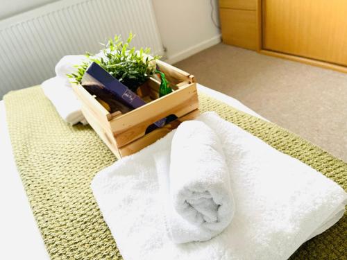 a crate of towels and a plant on a bed at 2 Bed House, Sleeps 6, Dog Friendly, Close to A14 M11, with Garden & Parking LONG STAY WORK CONTRACTOR LEISURE, JADE in Cambridge