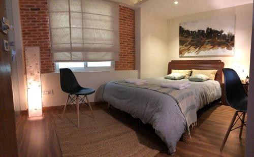 una camera da letto con un letto con due sedie e una finestra di TARA ART HOUSE a Patan