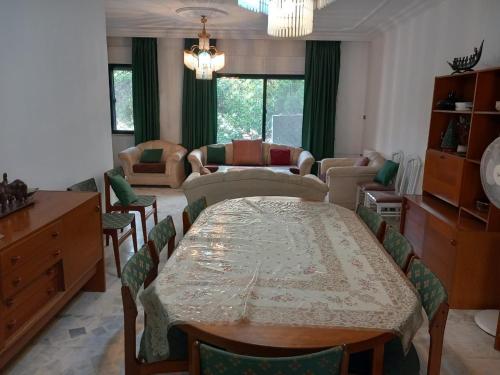 a dining room with a table and a living room at Abdoun ground floor apartment in Amman