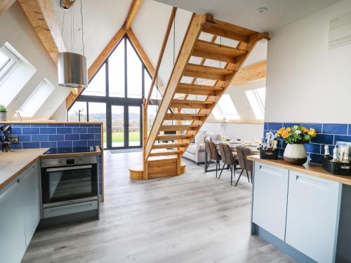 a kitchen with blue tiles and a dining room with a table at Hill Radnor - The Sheepfold in Llandrindod Wells
