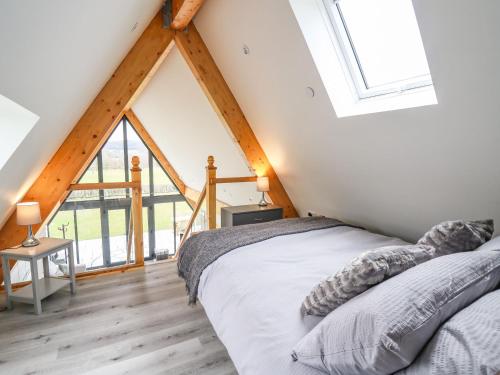 a bedroom with a bed and a large window at Hill Radnor - The Sheepfold in Llandrindod Wells