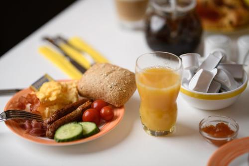 a table with a plate of food and a glass of orange juice at Hotel Hannover Airport by Premiere Classe in Hannover
