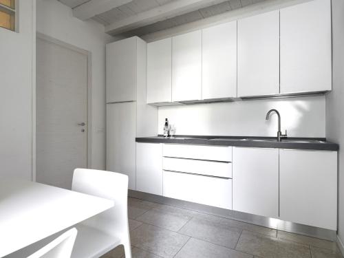 a kitchen with white cabinets and a sink at Academia Resort in Bergamo