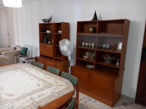 a living room with a table and a room with a fan at Abdoun ground floor apartment in Amman