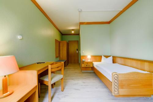 a bedroom with a bed and a desk and a bed sidx sidx sidx at Hotel Hannover Airport by Premiere Classe in Hannover