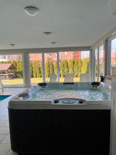 a jacuzzi tub in a room with windows at Wellness apartman in Siófok