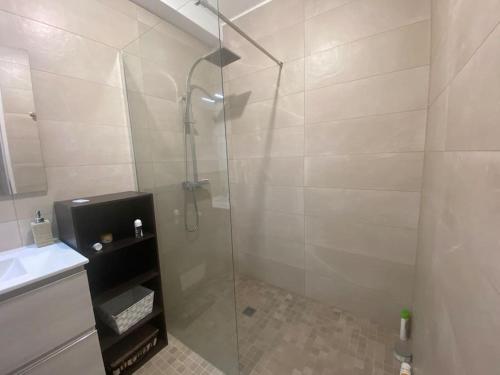 y baño con ducha y puerta de cristal. en Appartement 100 m2 Terrasse Piscine, en Gruissan