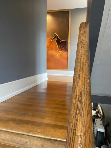 a wooden floor in a room with a painting on the wall at La maison des douceurs in Bussang