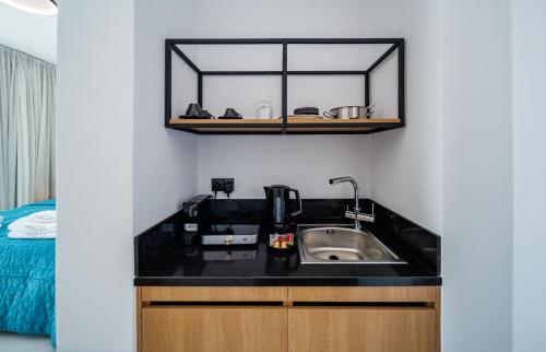 a kitchen with a sink and a mirror at Regency Boutique Hotel Holiday Suites in Paphos